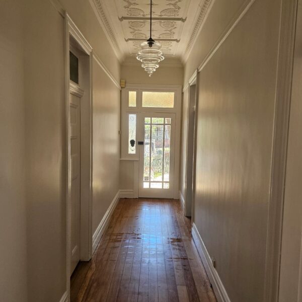 Hallway of the original Ashbury cottage with pressed metal ceiling and timber floor