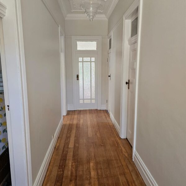 Hallway of the Ashbury cottage leading to the original glazed front door